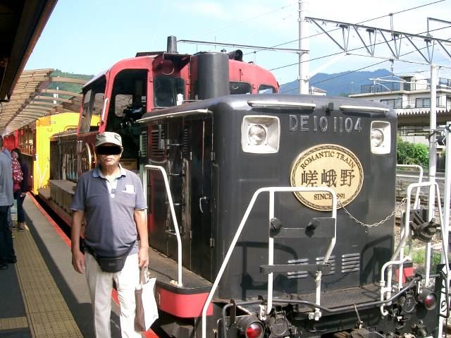 これから乗車するトロッコ列車を押していくディーゼル機関車の前で駅員に撮影してもらった